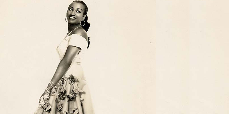 Celia Cruz performing on stage, singing with passion and joy